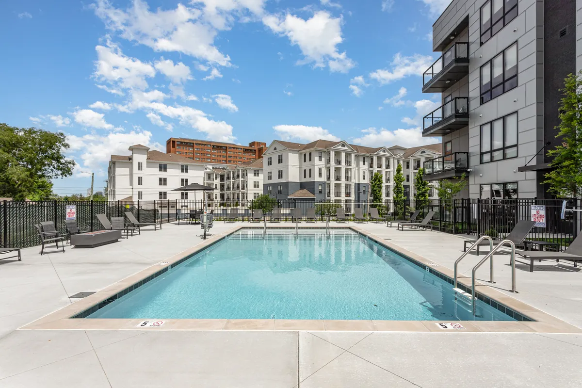 An exterior shot of another swimming pool area with lounge chairs, surrounding buildings, and landscaped details. The mood is relaxed and social, highlighting the communal aspect of the amenities.