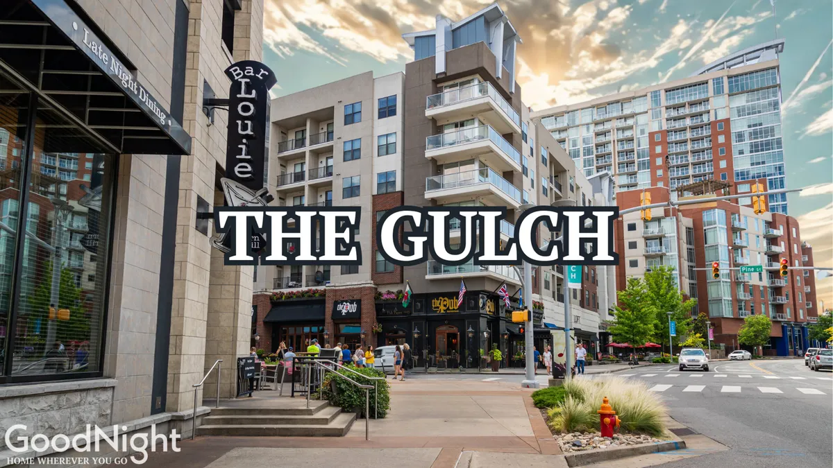 An energetic streetscape featuring Bar Louie, modern apartment buildings, and a bustling outdoor dining area. The scene exudes vibrancy, with people dining and socializing in an urban, walkable environment.